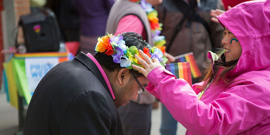 Person places pride floral crown on someone's head