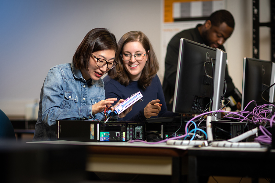 women students working at putting a computer together