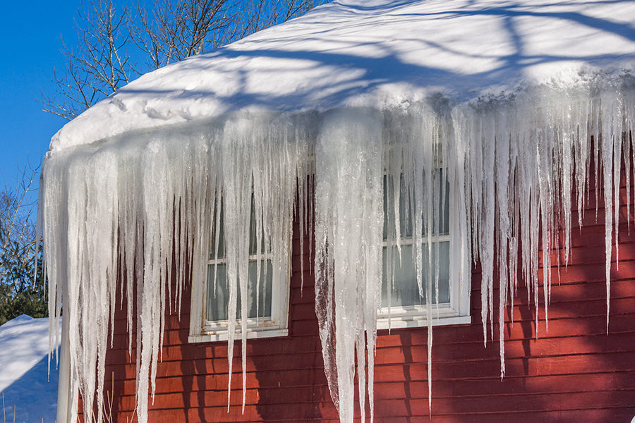 large ice dam on the side of the roof of a house