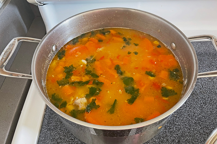large pot of vegetable soup cooking on a stove