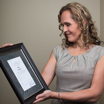 Marni Panas with a copy of Bill 7 signed by Kathleen Ganley, minister of justice and solicitor general. Panas helped write the language for the bill.