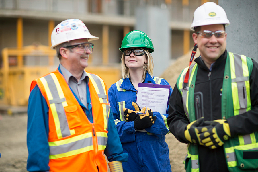 construction and project managers gathered at a worksite talking and smiling