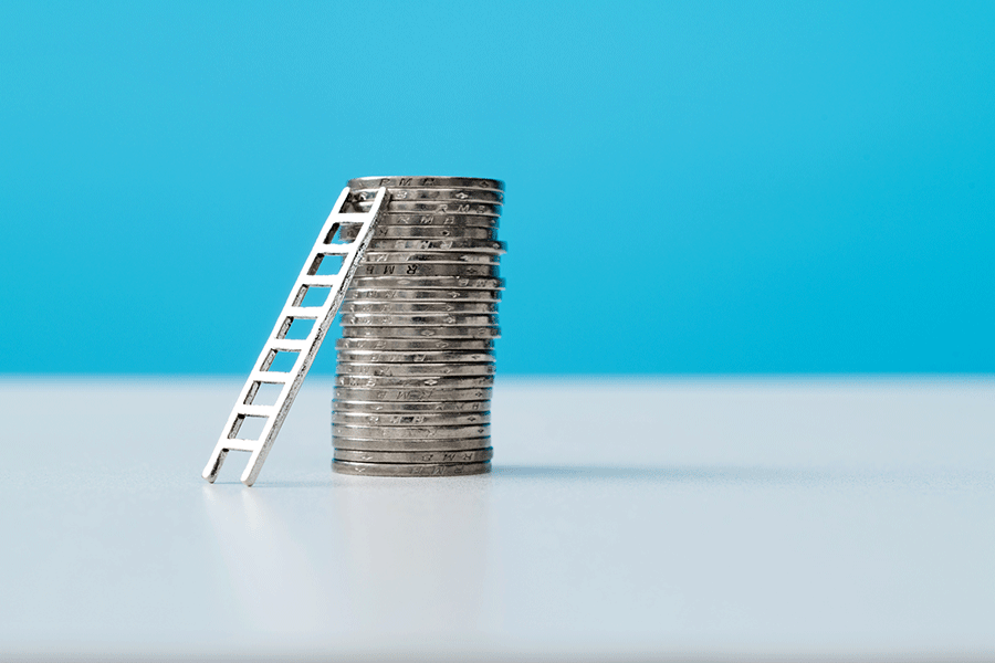 stack of silver coins with tiny ladder leading to the top of it