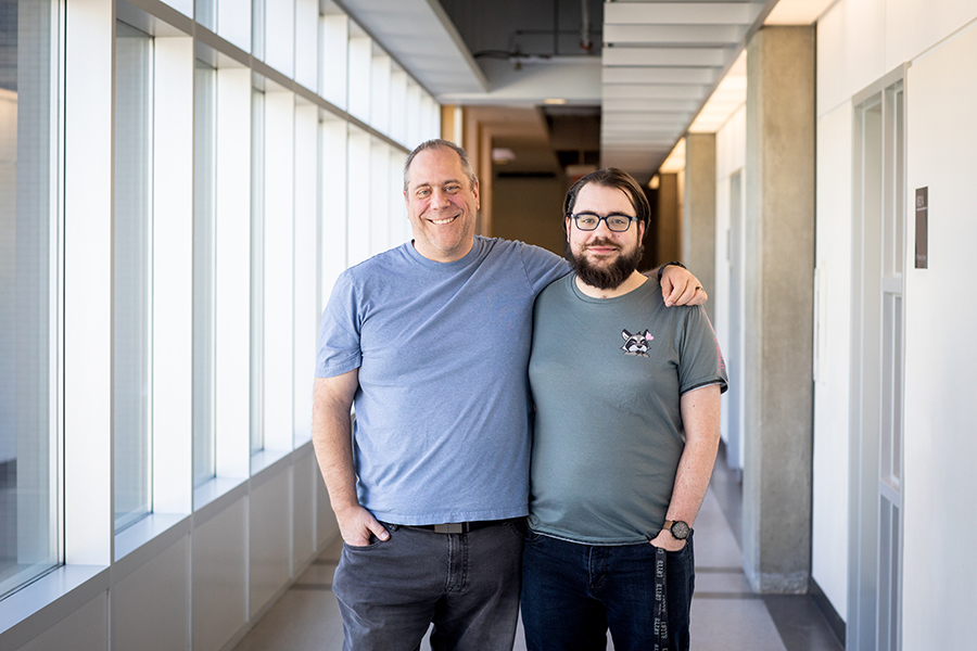 father and son bill and taylor knopp, NAIT network engineering technology grads, standing in a pedway on campus